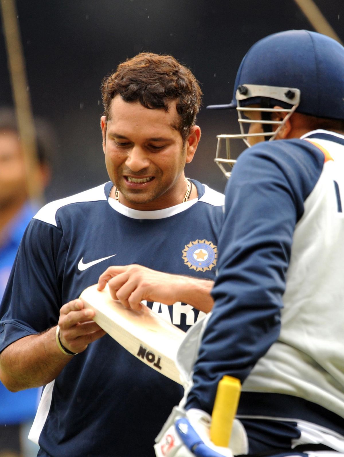 Sachin Tendulkar And Virender Sehwag Look Closely At A Bat