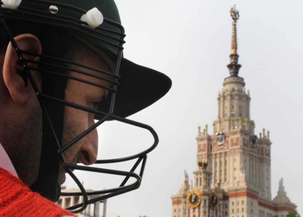A cricketer during a game on a pitch in front of Moscow's State University