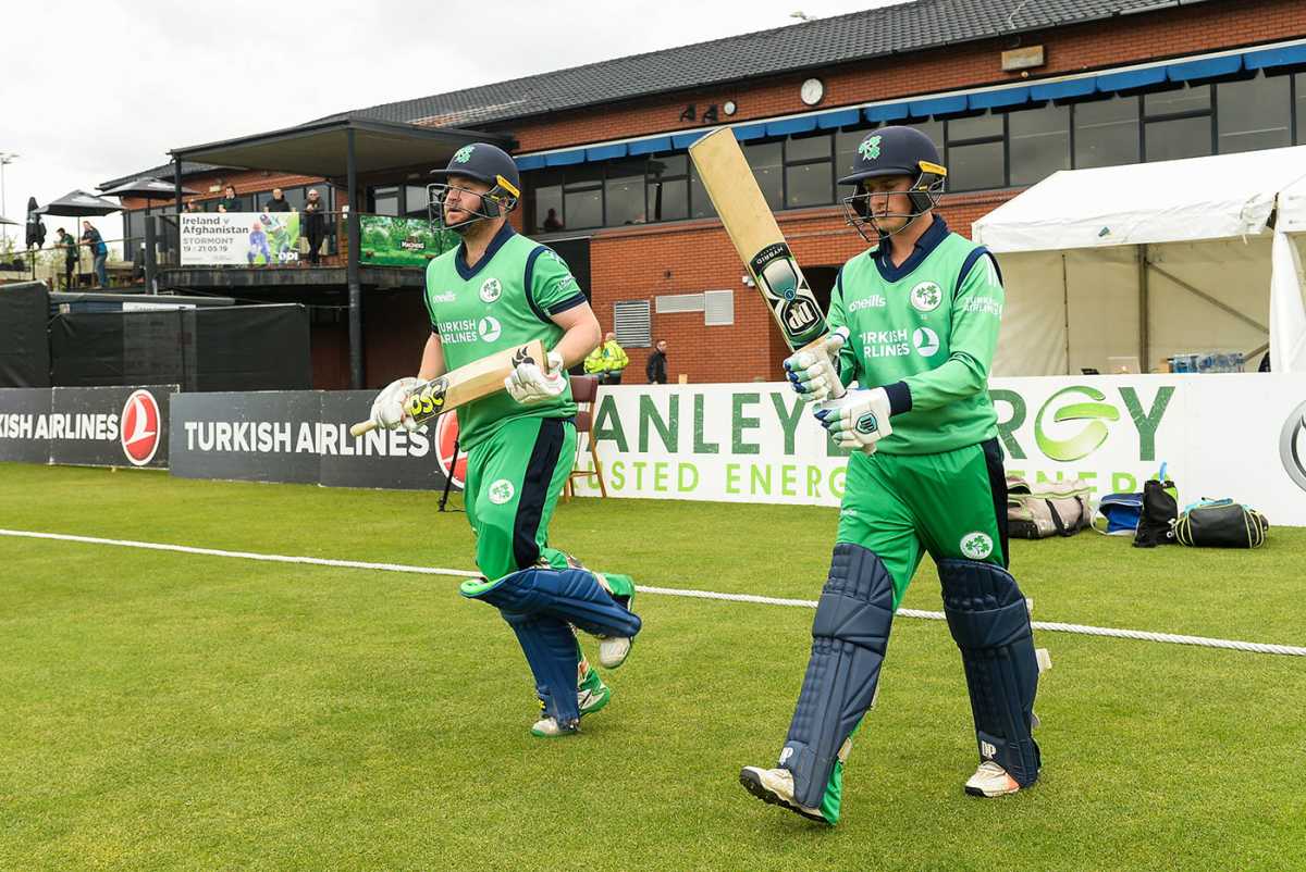 Paul Stirling and James McCollum walk out to bat at the Civil Service ground in Stormont