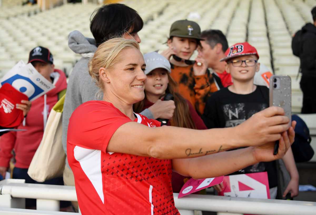 Katherine Brunt takes a selfie with some fans after the game