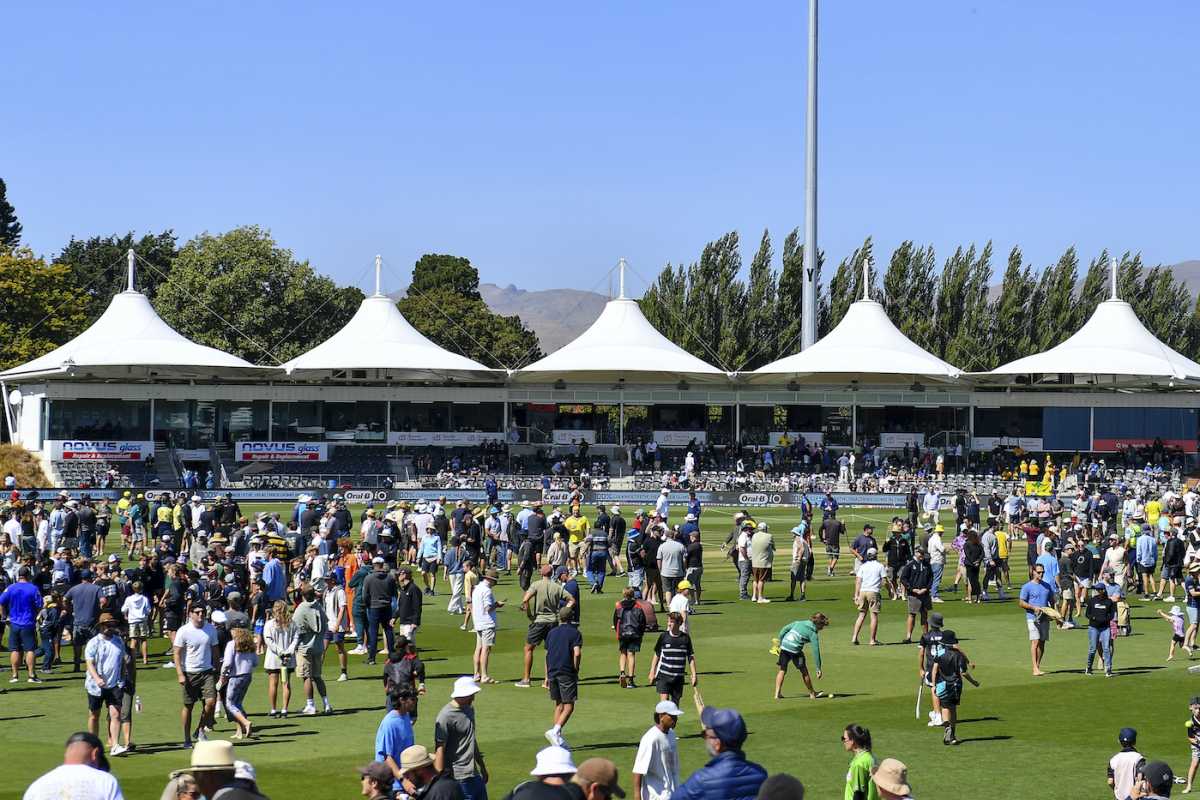 Spectators at Hagley Oval get on the field during the lunch break