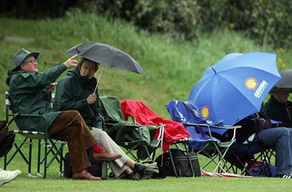 Spectators take shelter during the 1st round of the C&G Trophy, Berkshire v Gloucestershire, Reading Cricket Club, May 2