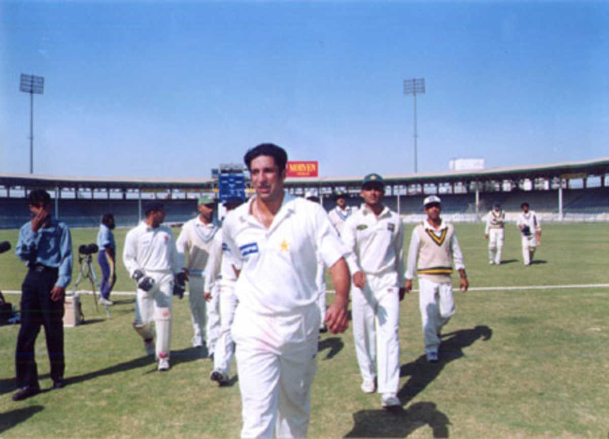 Wasim Akram leads his team off the ground