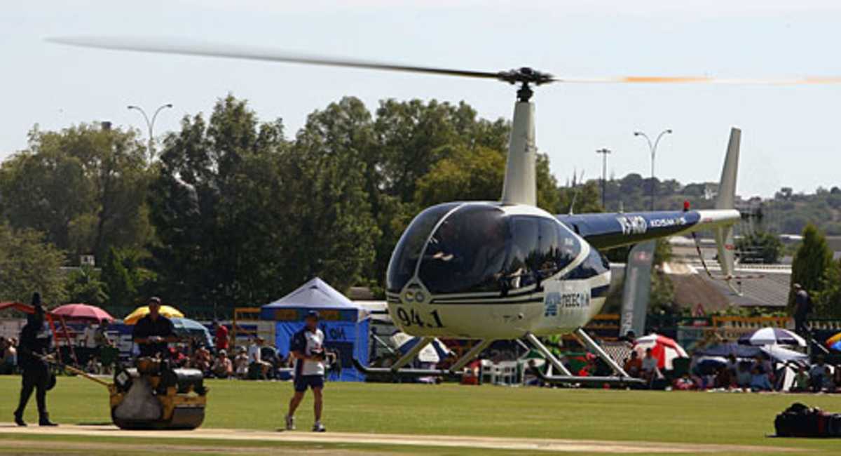 A helicopter flies over the wicket to help dry it out before the start of the one-day match between Namibia and England