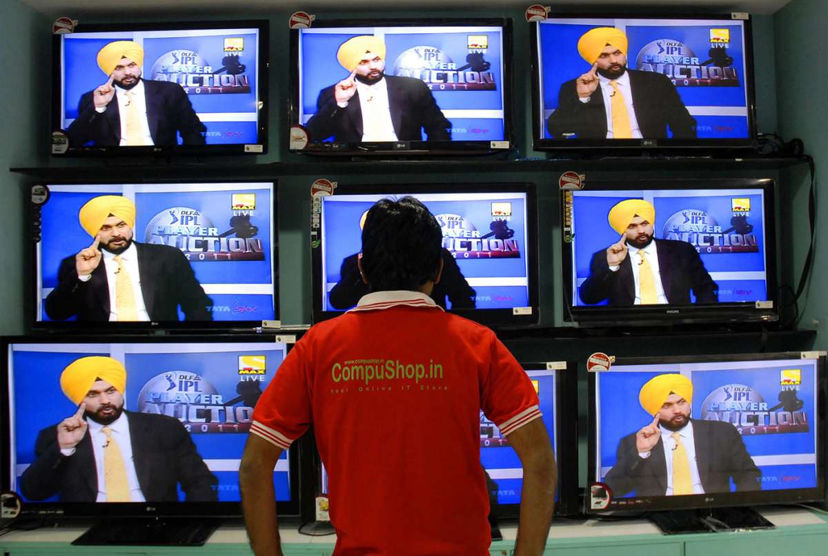 A man watches the IPL auction on a bank of television sets ESPNcricinfo