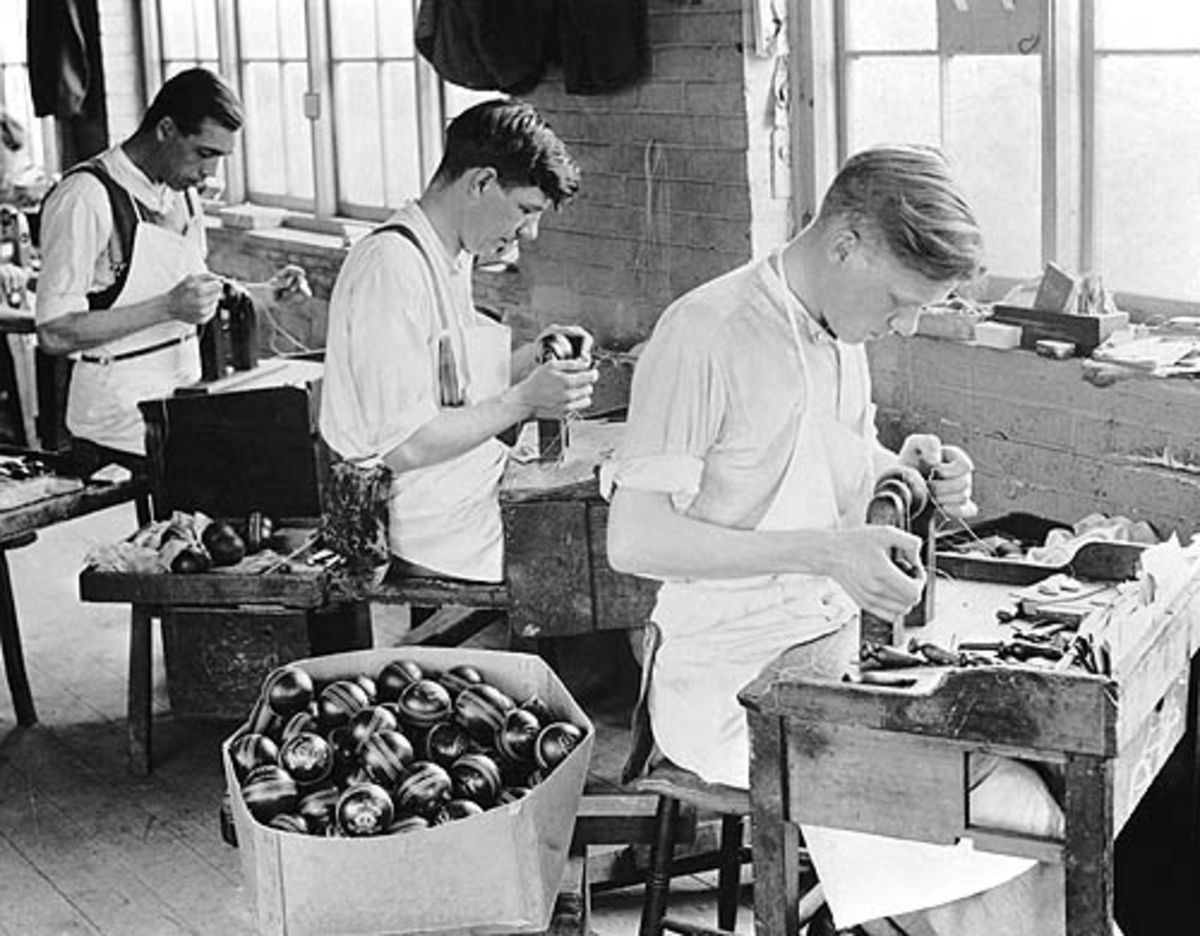 Workers stitch cricket balls at a factory