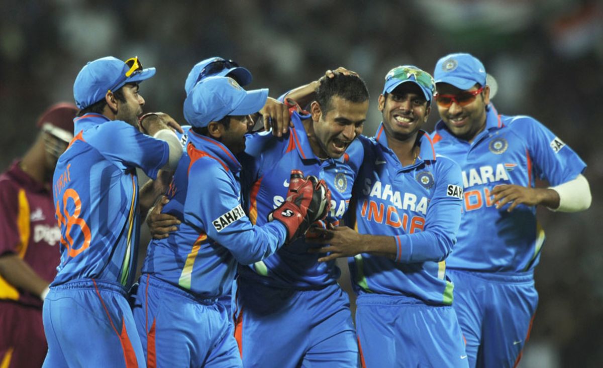 Irfan Pathan is mobbed by his team-mates after striking with his first ...