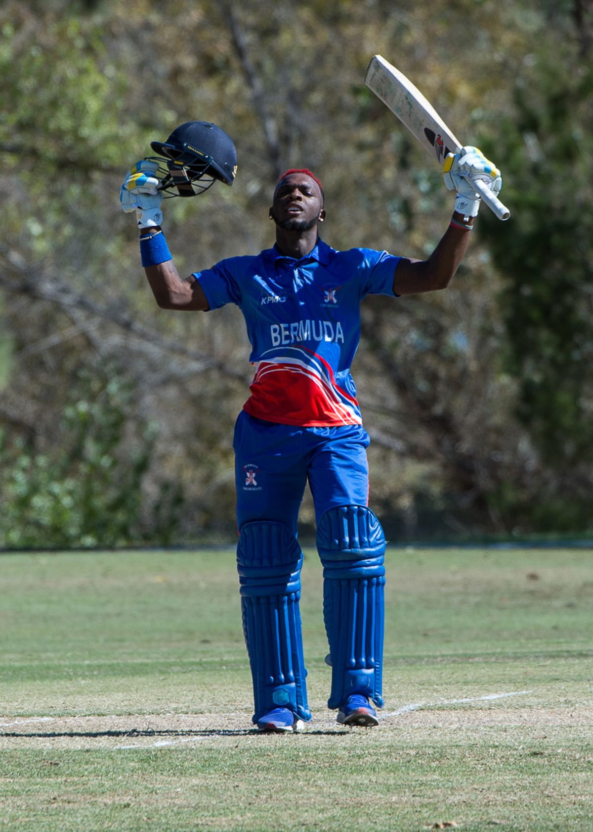 Kamau Leverock raises his bat upon reaching his century off 96