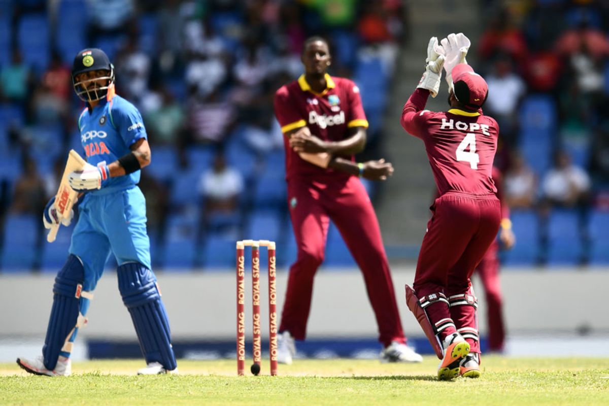 Virat Kohli watches and Jason Holder prepares to celebrate as Shai Hope gets under a catch