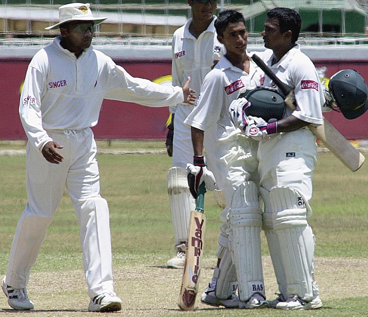 Bangladeshi batsman Aminul Islam sweeps a ball as Sangakkara looks on