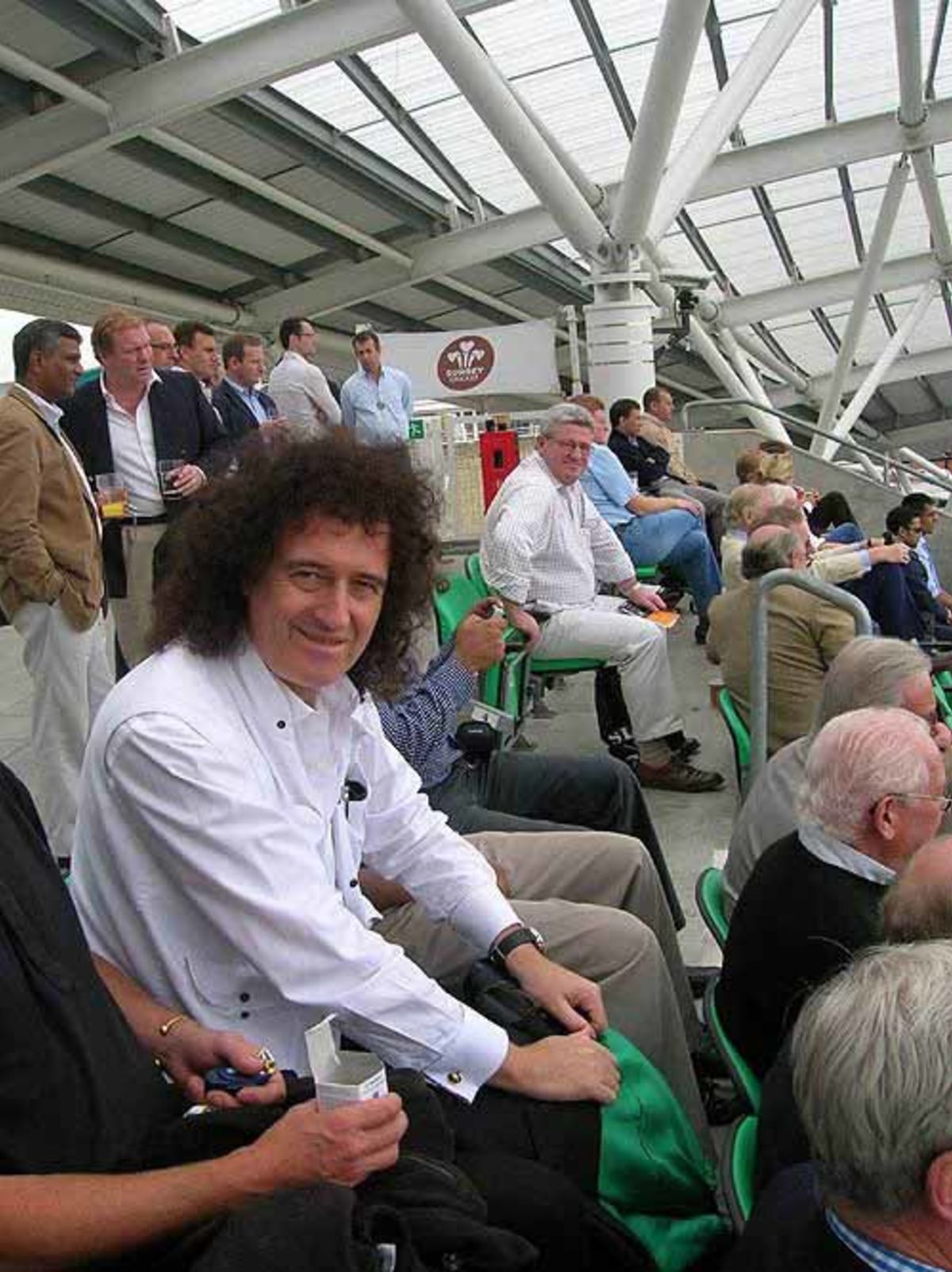 Brian May, the lead guitarist of the rock band Queen, watching cricket