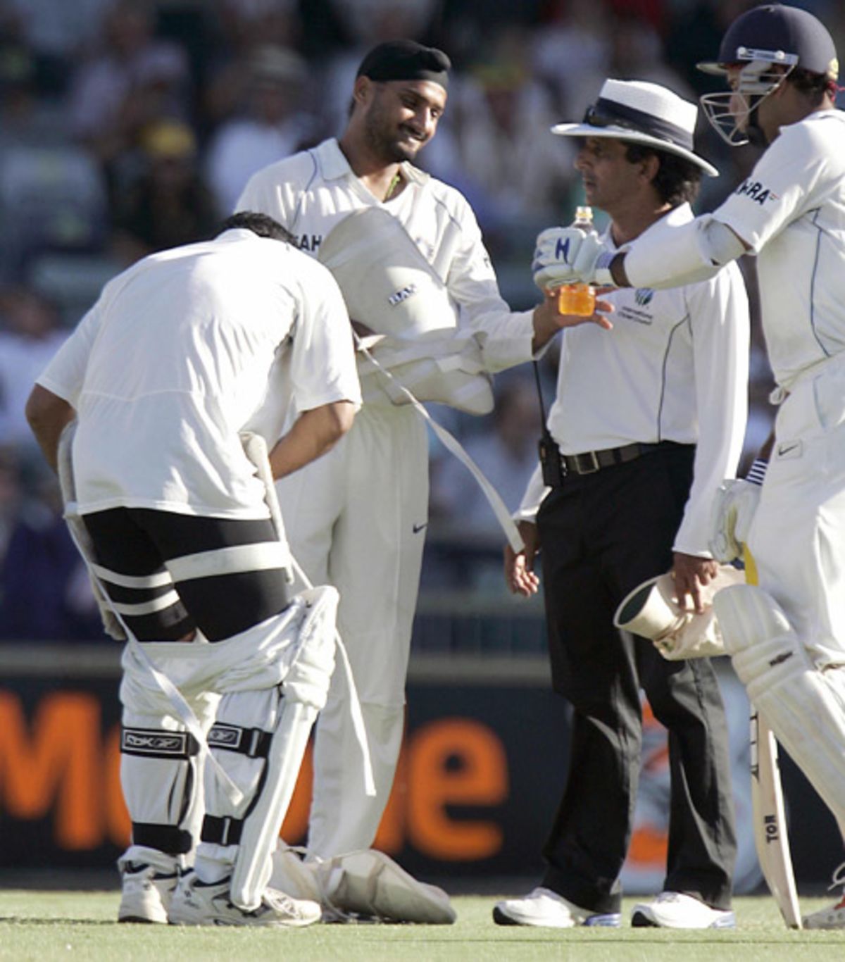 Asad Rauf keeps a close watch on proceedings while Mahendra Singh Dhoni  changes his thigh pad | ESPNcricinfo.com