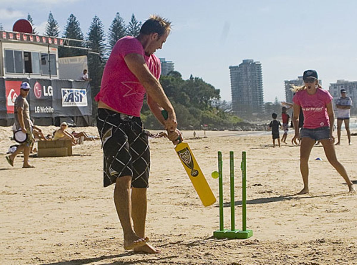 Australian surfers and cricketers pose for photos at a beach cricket
