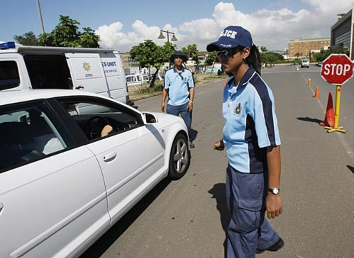 A security guard checks a car