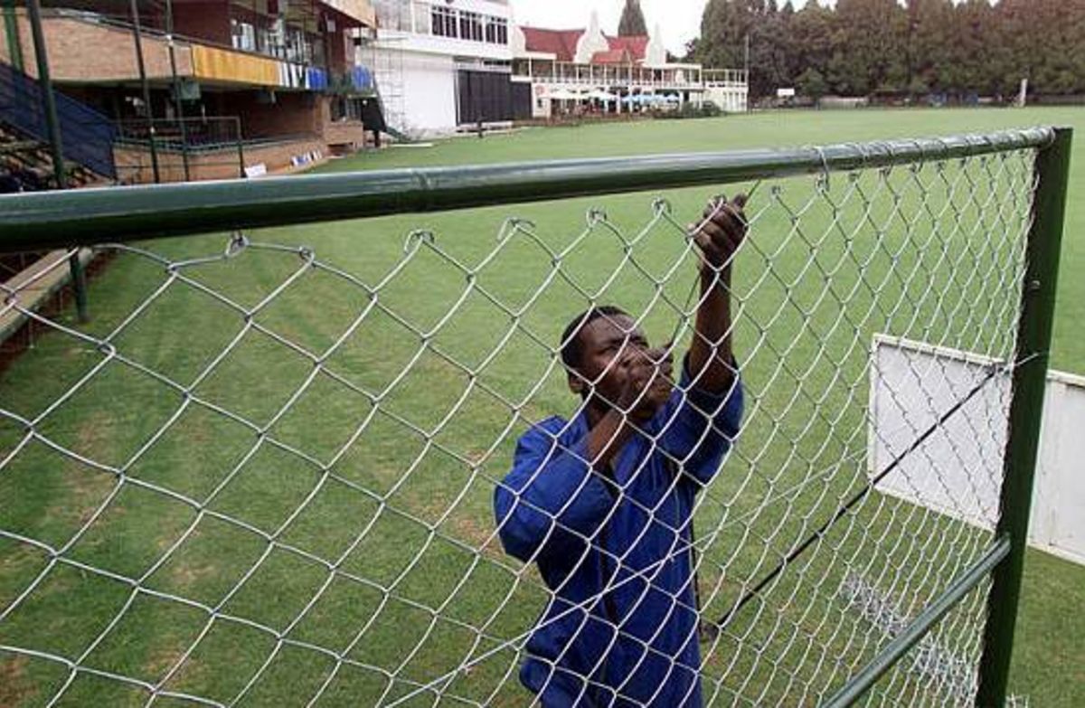 A Zimbabwean worker puts up a fence at the Harare Sports Club