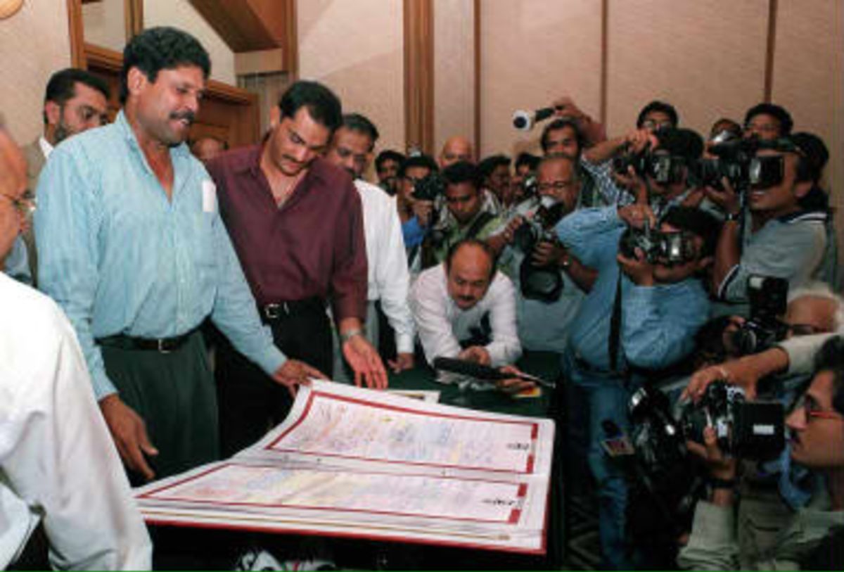 Indian captain of the victorious 1983 World Cup Kapil Dev  shows the 'Good Luck India' book in Bombay 23 April 1999 to Mohammed Azaruddin,  captain of the Indian 1999 World Cup cricket team just before the team departs for England. The book travelled all major cities of India and is filled with words of inspiration and good wishes of people from all walks of life.
