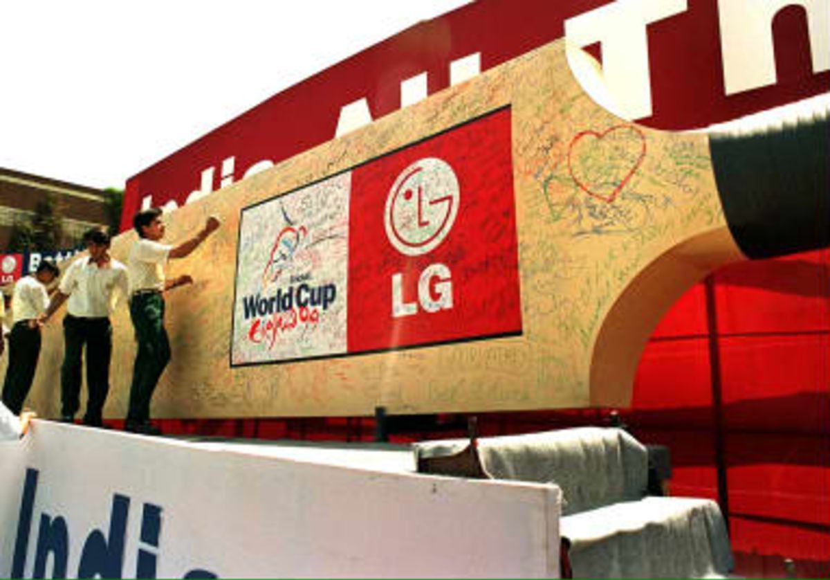 Indian supporters inscribe good luck messages on a giant cricket bat during an pre World Cup event sponsored by electronics giant LG  16 April 1999 in New Delhi.
