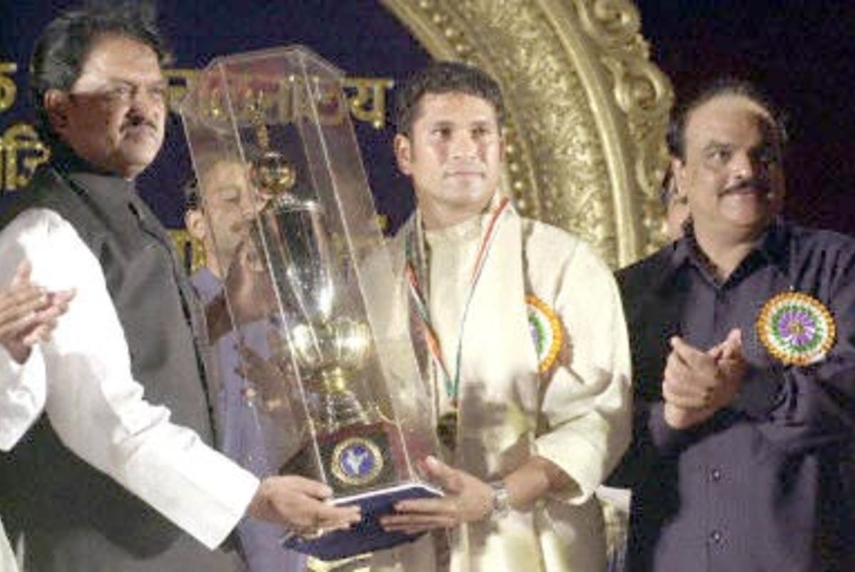 Indian cricket great Sachin Tendulkar (C) poses with his 'Maharashtra Bhushan' award, after receiving it from Maharashtra Chief Minister Vilasrao Deshmukh (L) as Maharashtra deputy Chief Minister Chagan Bhujbal (R) applauds 01 May 2001. Maharashtra's highest award was conferred to Tendulkar for his outstanding achievement in cricket.