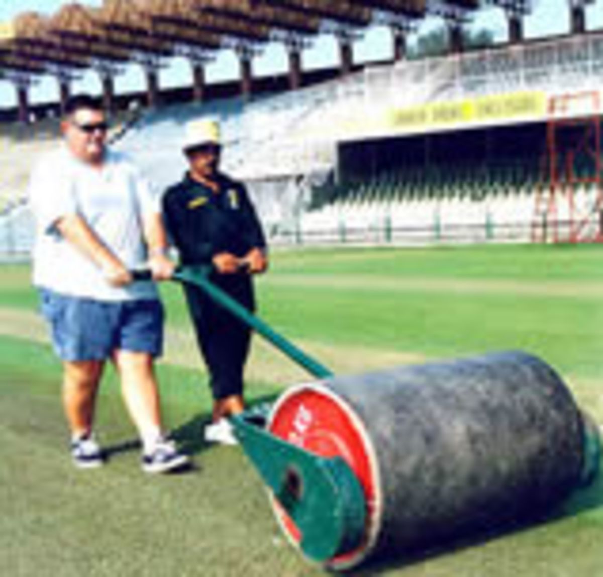 English curator Andy Atkinson and a local groundsman rolling a practice pitch