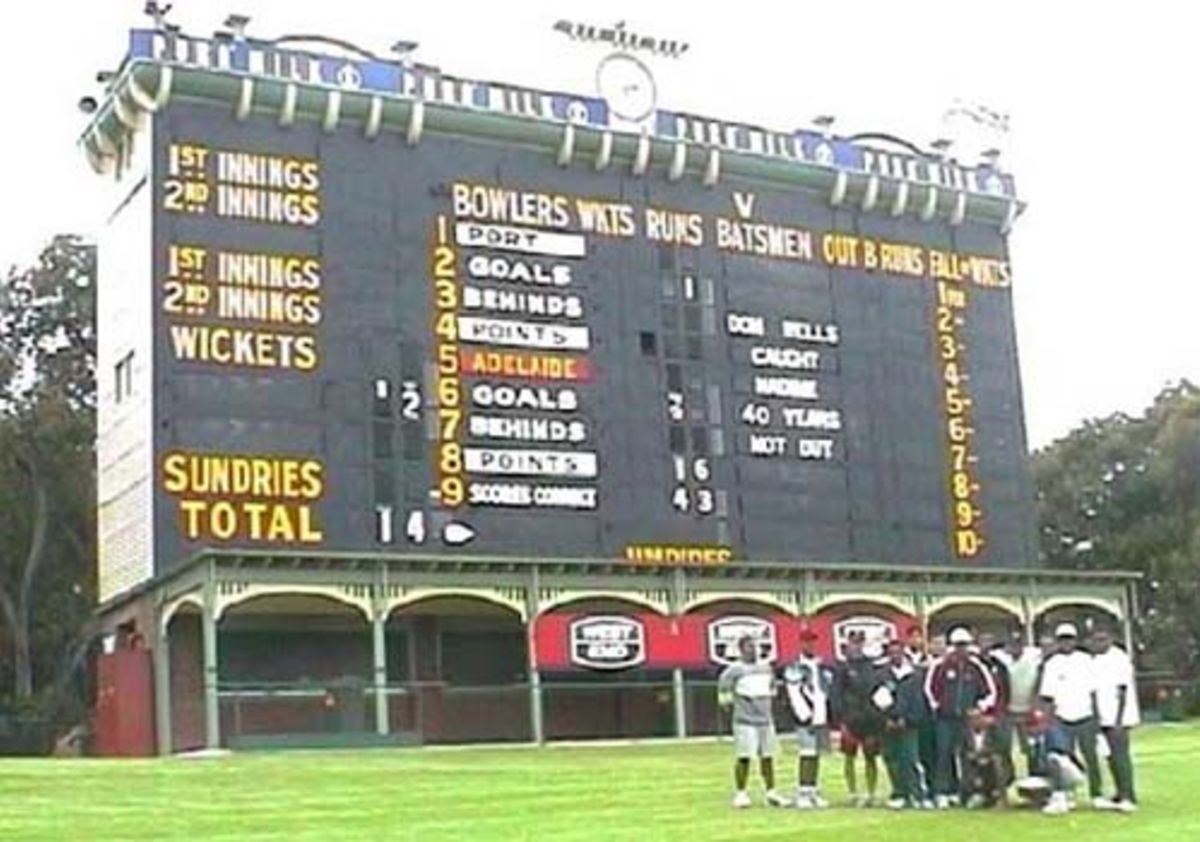 The 15 EAP Cricket Academy attendees in front of the famous Adelaide Oval Scoreboard