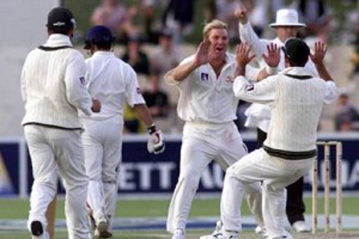 11 Dec 1999: Shane Warne of Australia celebrates the wicket of Rahul Dravid of India with team mate Ricky Ponting with umpire Daryl Harper raising his finger in the background, on two of the first test between Australia and India, at the Adelaide Oval, Adelaide, Australia.