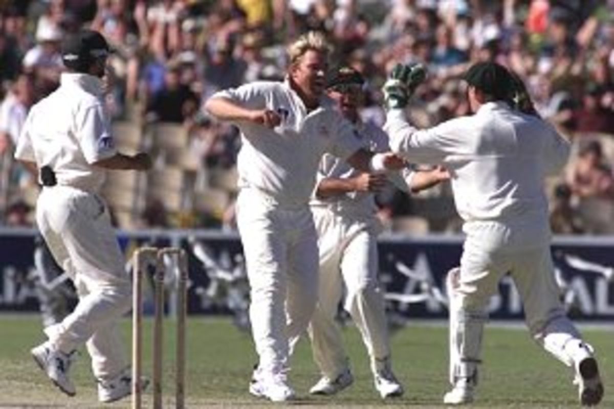 13 Dec 1999: Shane Warne of Australia celebrates with Adam Gilchrist after Gilchrist caught Rahul Dravid of India off Warne for six, on day four of the first test between Australia and India, at the Adelaide Oval, Adelaide, Australia.