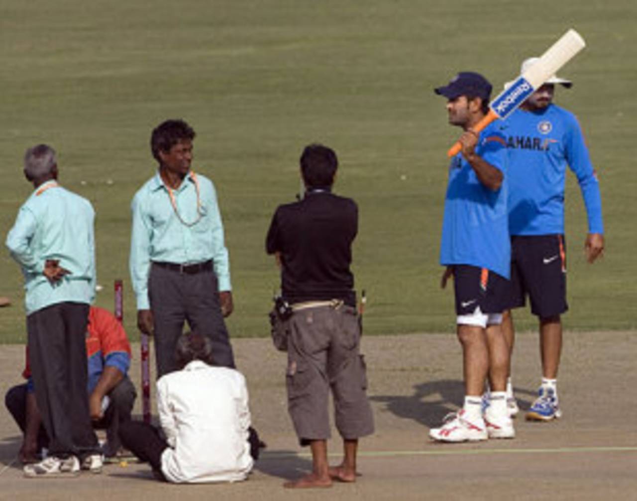 MS Dhoni has a chat with the groundsmen while Harbhajan Singh inspects the pitch, Delhi, October 30, 2009