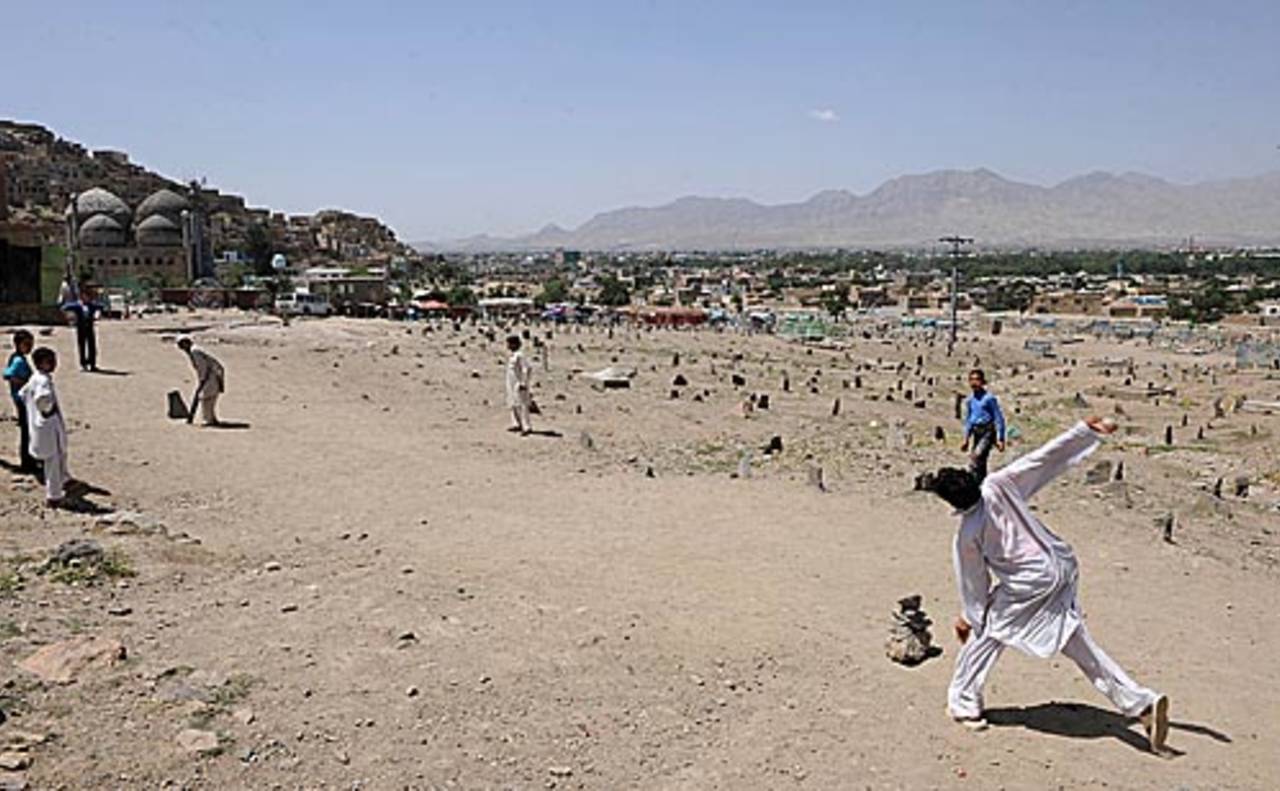 Afghan boys play cricket near a cemetery in Kabul, June 1, 2010