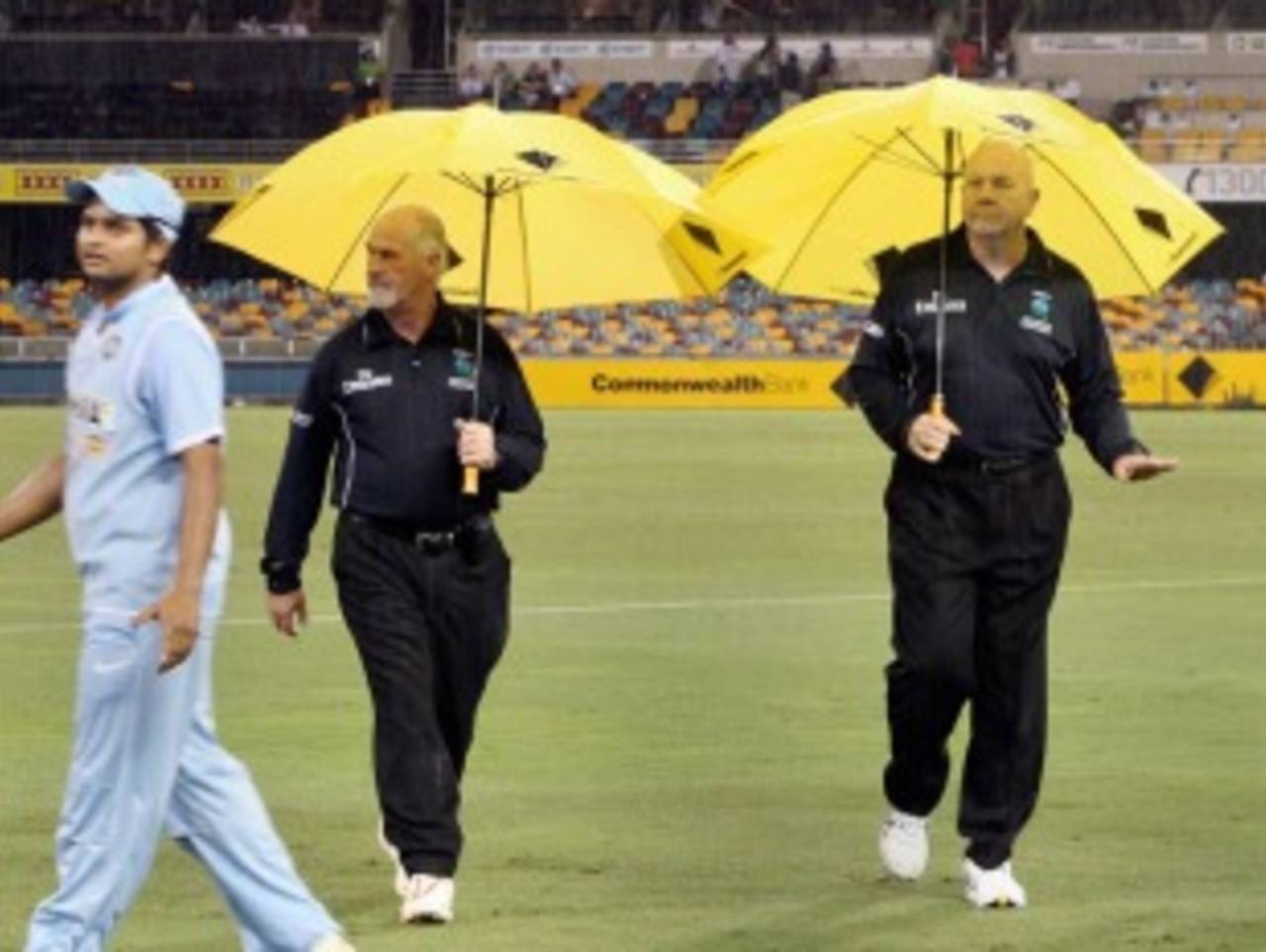 Umpires Steve Davis and Rudi Koertzen walk out to the middle with umbrellas, India v Sri Lanka, CB Series, February 5, 2008