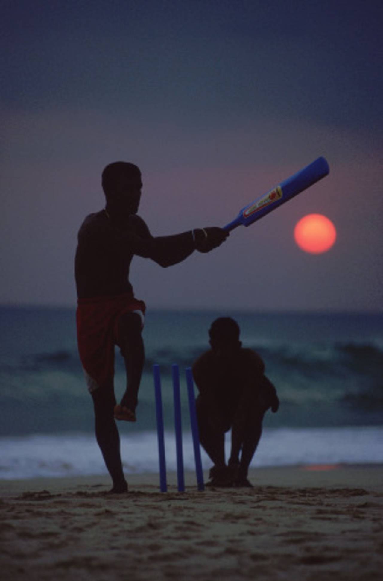 Locals play cricket on the beach
