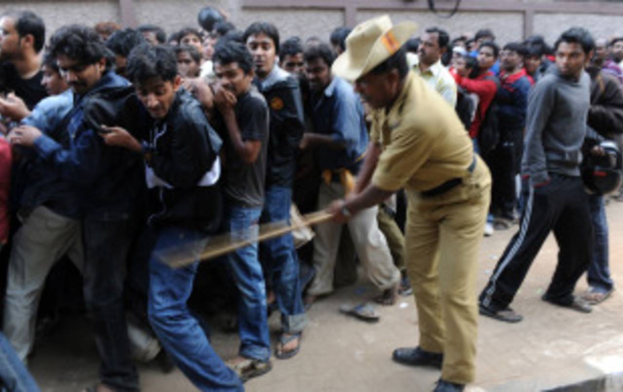 A policeman uses a lathi (bamboo stick) to control the crowd queuing up for tickets for the India - England game at the M Chinnaswamy stadium in Bangalore&nbsp;&nbsp;&bull;&nbsp;&nbsp;AFP