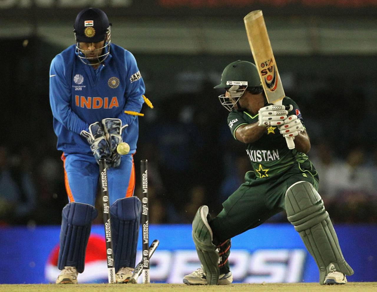 MS Dhoni watches as Asad Shafiq's middle stump is pegged back by Yuvraj Singh, India v Pakistan, 2nd semi-final, World Cup 2011, Mohali, March 30, 2011
