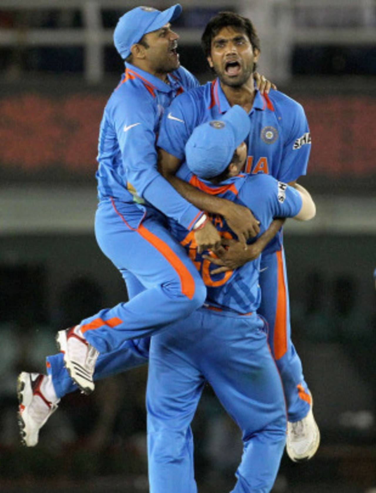 Suresh Raina inexplicably holds Munaf Patel and Virender Sehwag aloft after Abdul Razzaq's dismissal, India v Pakistan, 2nd semi-final, World Cup 2011, Mohali, March 30, 2011