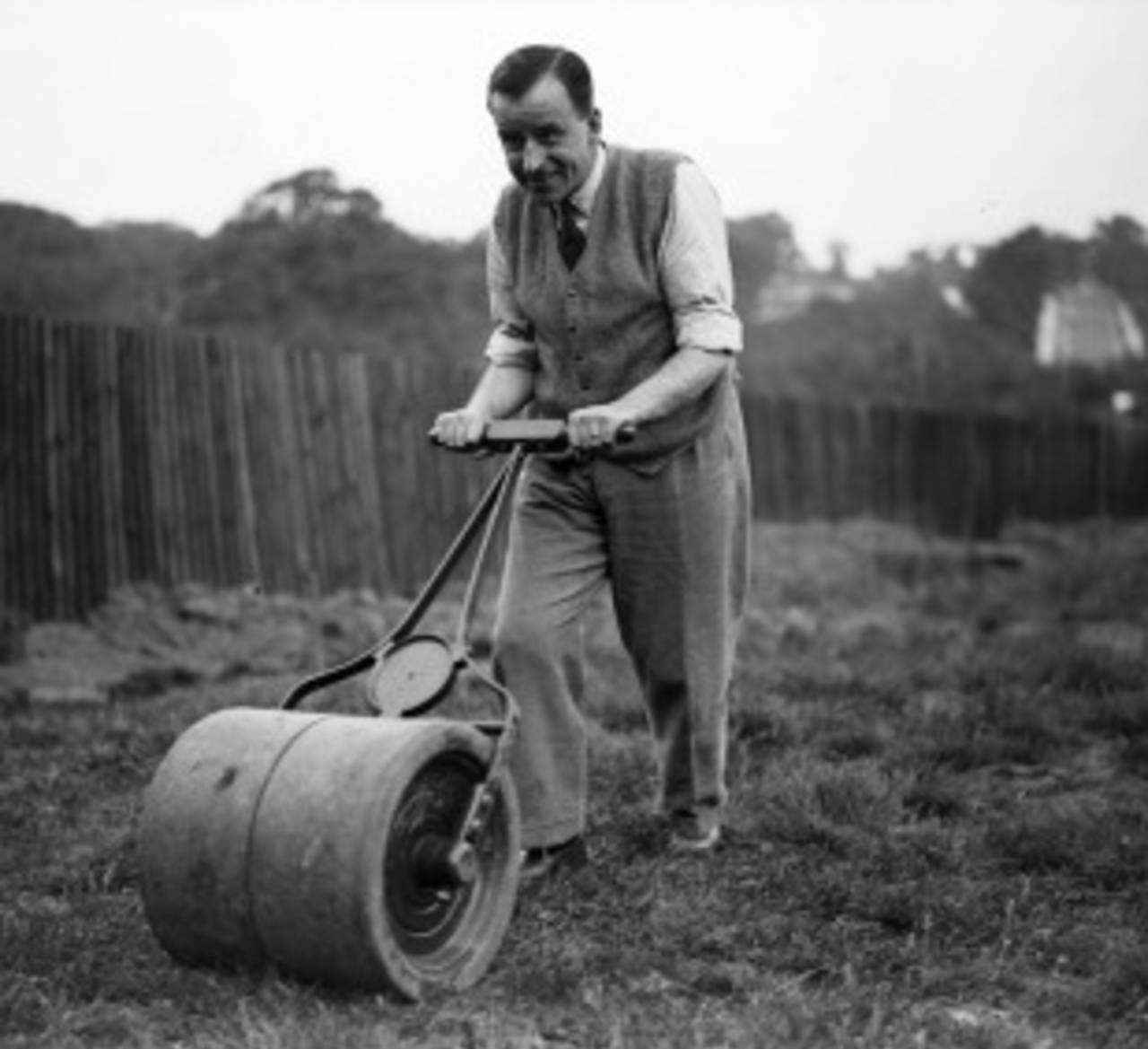 A roller is used in a backyard lawn, June 30, 1931