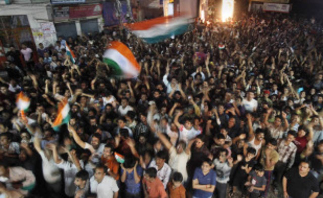 Indian flags are waved on a street in Guwahati, April 2, 2011