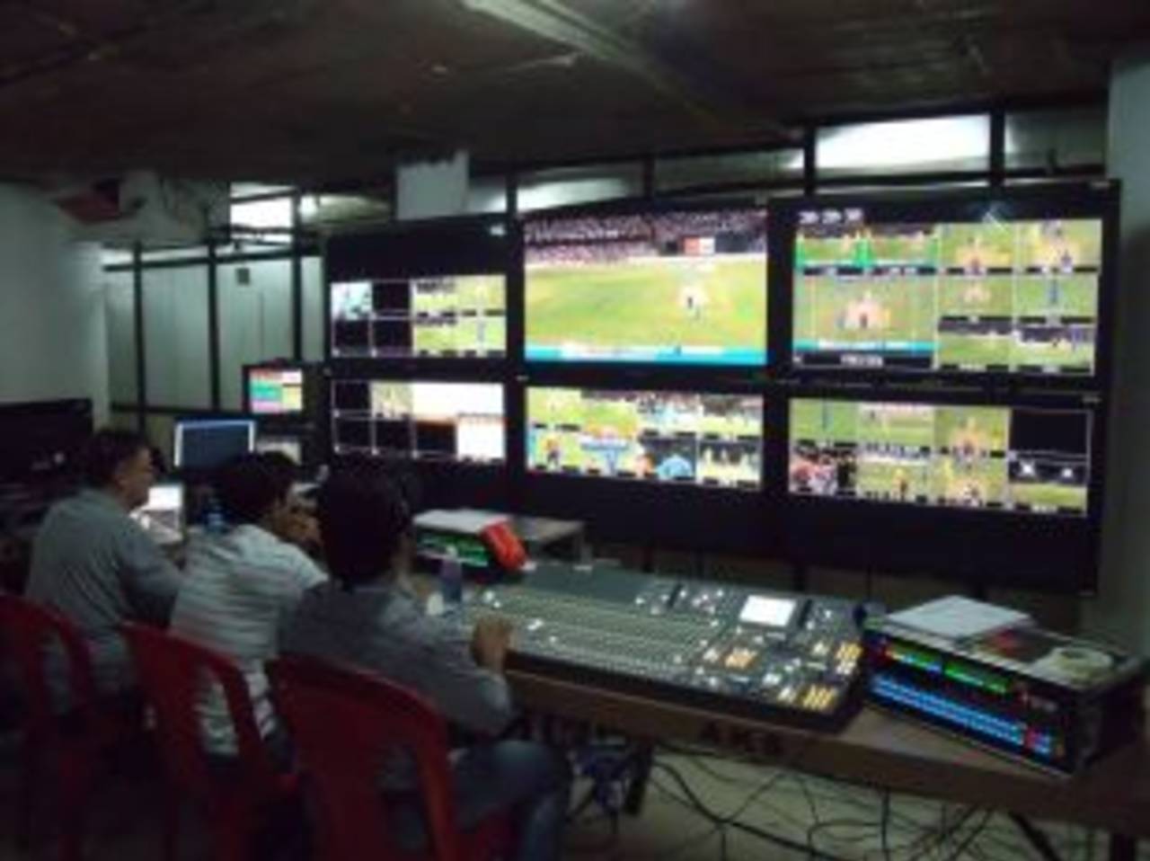 The vision mixer's desk and wall of monitors in the ESPN Star control room at a game