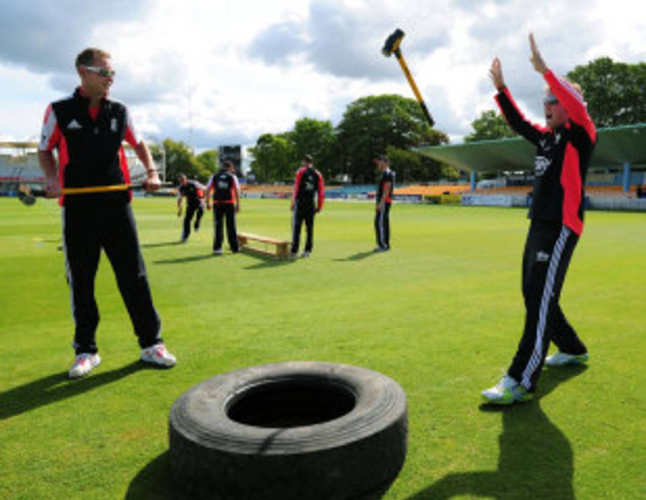 Stuart Broad watches as Graeme Swann loses his hammer during a training exercise that includes striking a rubber tyre, Bristol, June 24, 2011