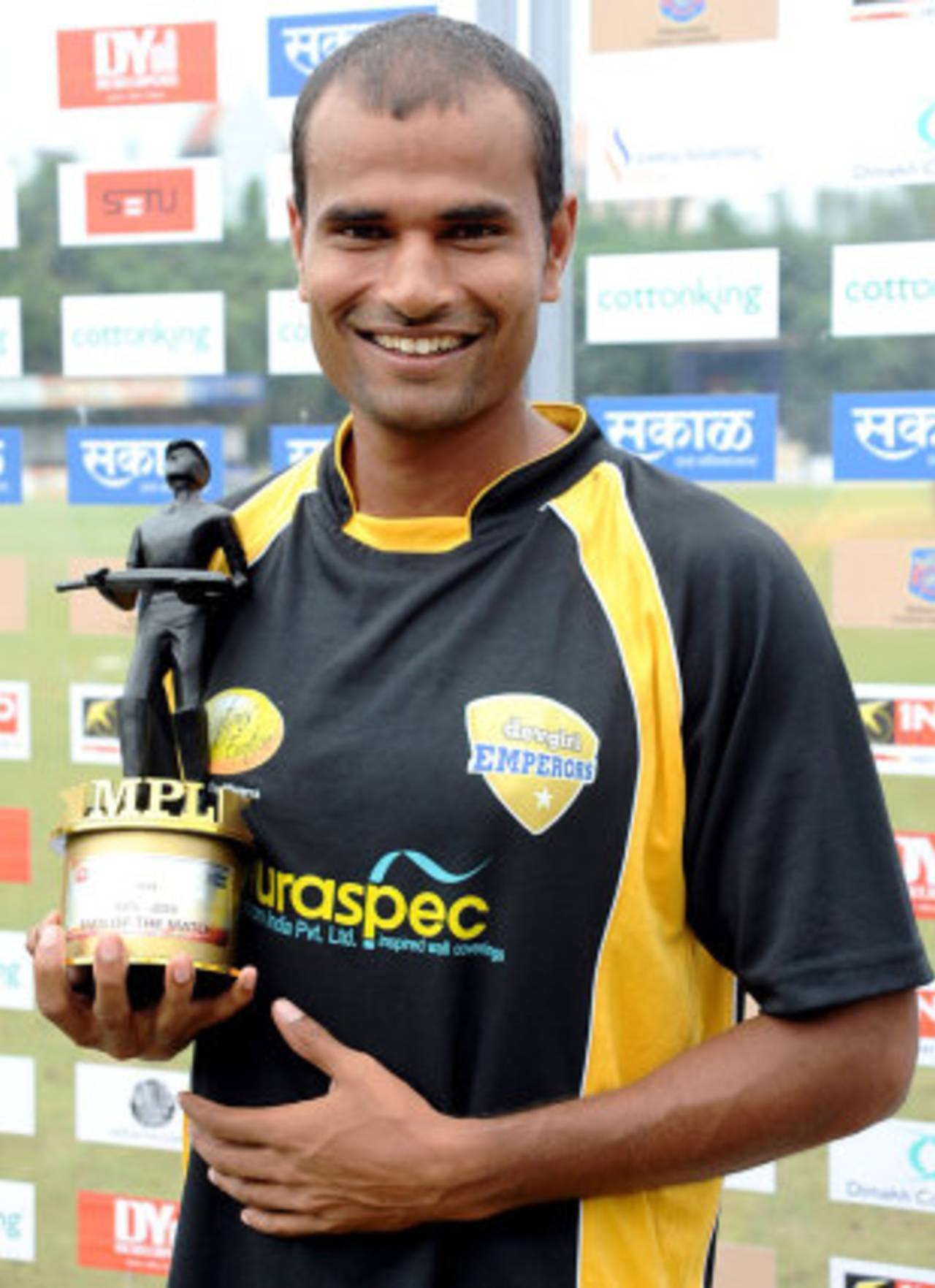Kishor Bhikane holds a Man of the Match award 