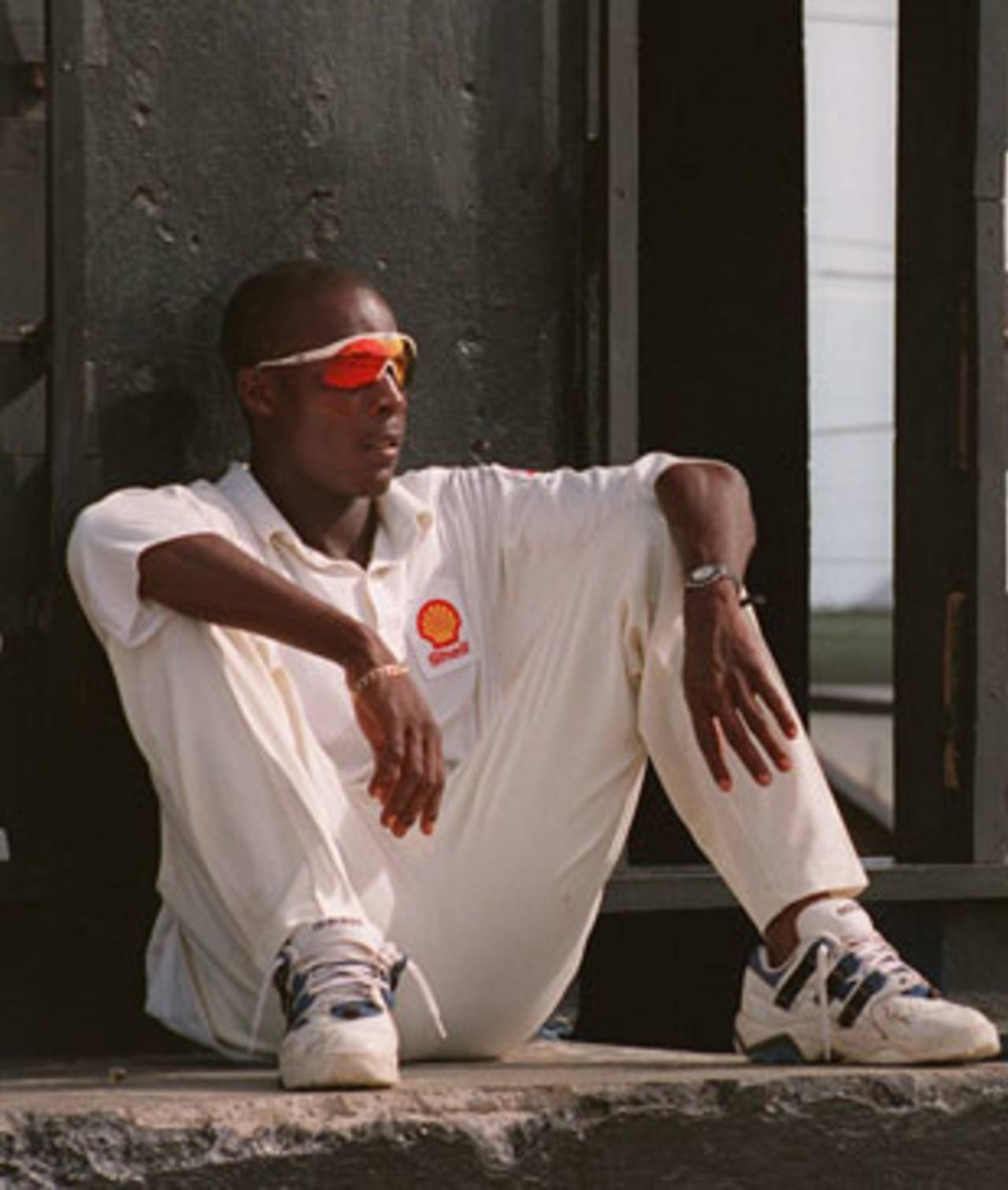 Vasbert Drakes takes a break by the scoreboard, West Indies Board XI v Australians, 3rd day, St Kitts, April 17, 1995