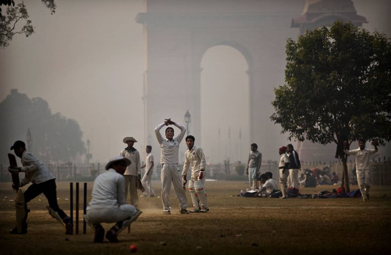 Weather is never a deterrent for cricket, youngsters play a match on a foggy day on the lawns near the India Gate