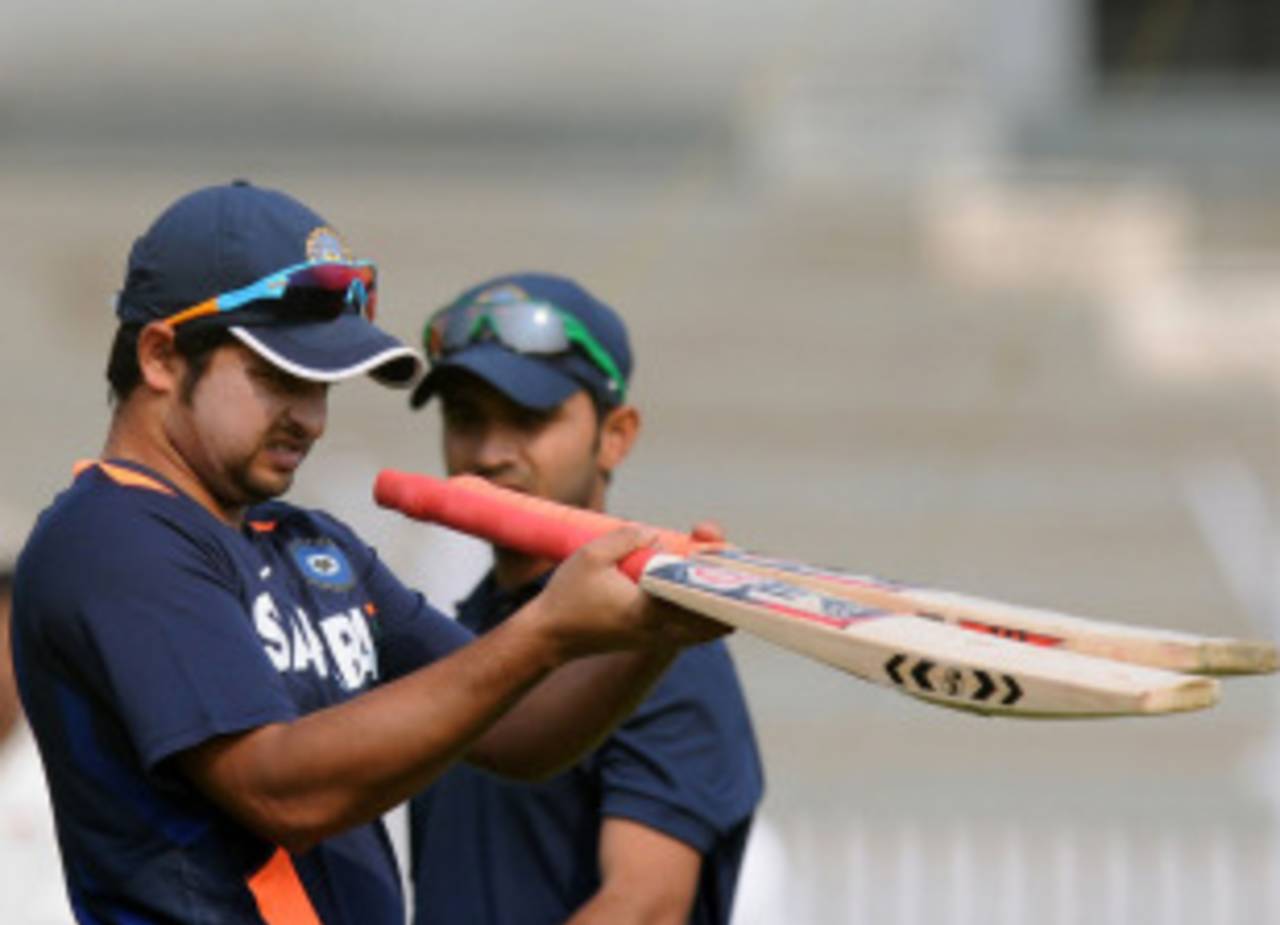 Suresh Raina inspects bats during a practice session ahead of India A's game against England, Mumbai, October 29, 2012