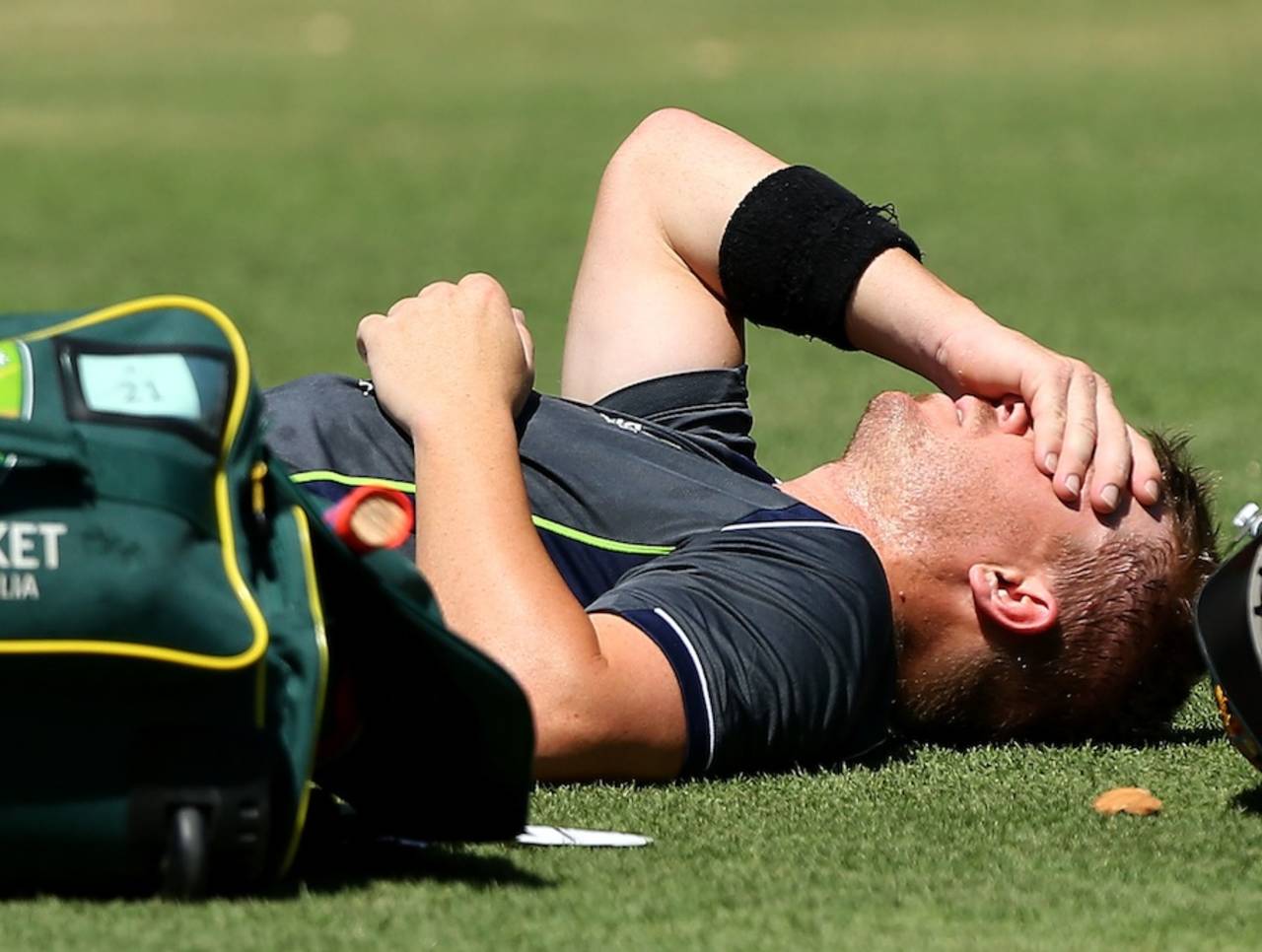 David Warner lies on the ground after getting hit on the hand while batting during a net session, Perth, January 30, 2013