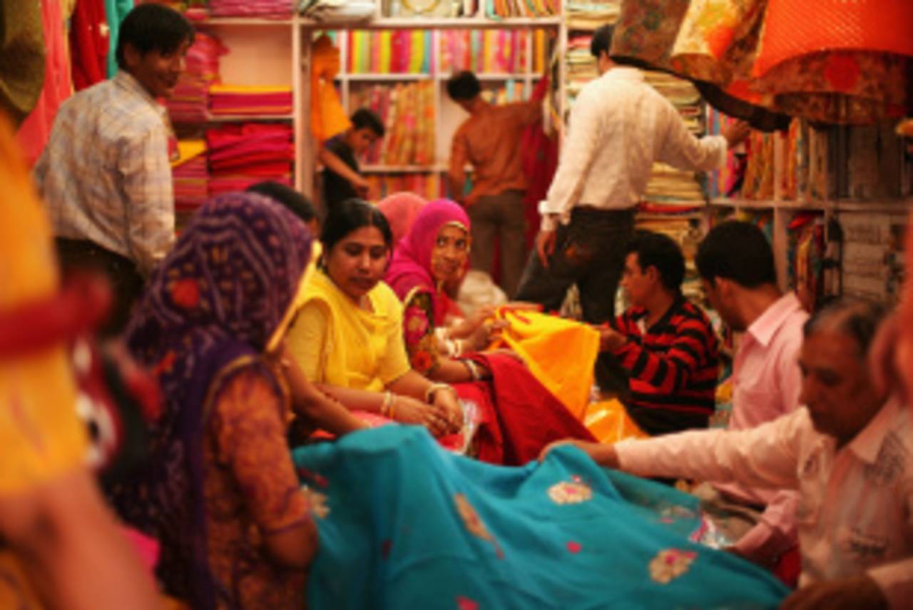 Customers look at material in a shop in the old walled city, Jaipur, April 6, 2010