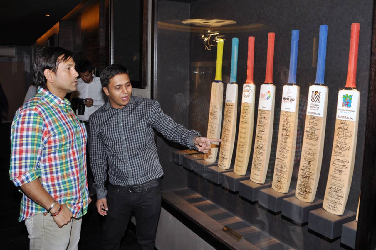 Sachin Tendulkar looks bats signed by members of every World Cup-winning squad at the cricket museum Blades of Glory, Pune