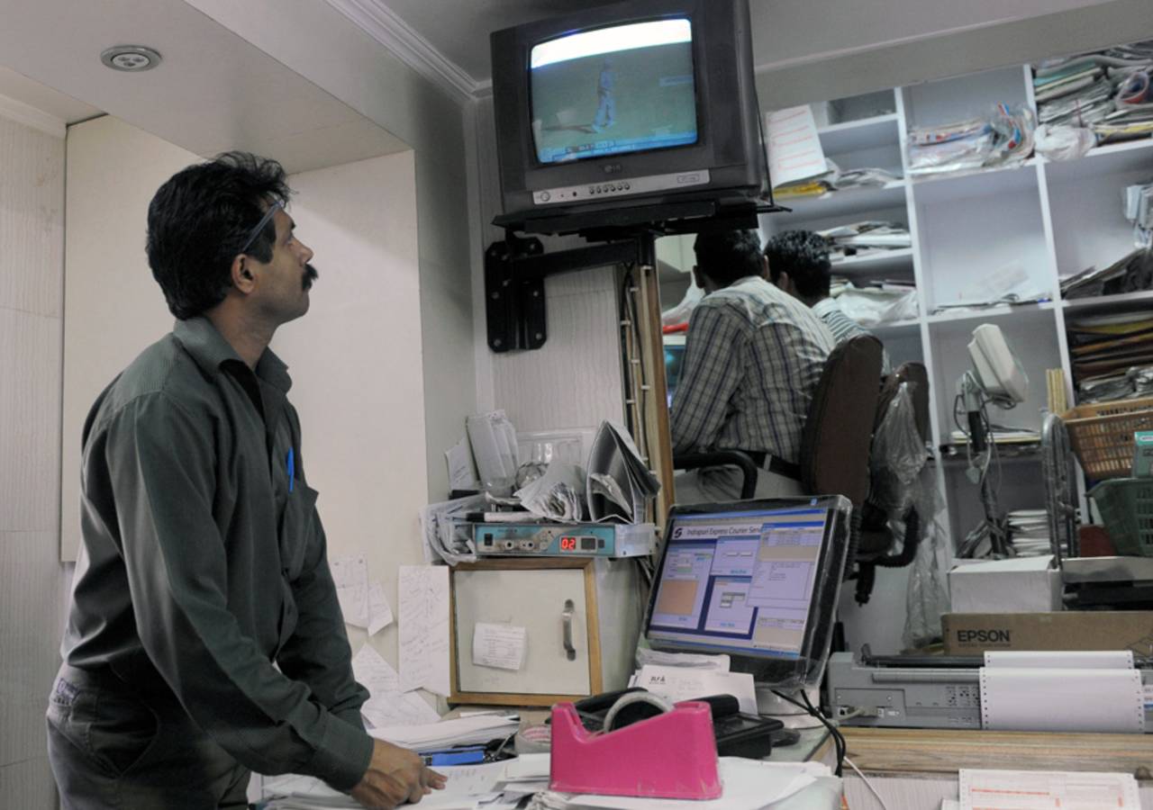 An office worker watches the World Cup final on TV, New Delhi, April 2, 2011