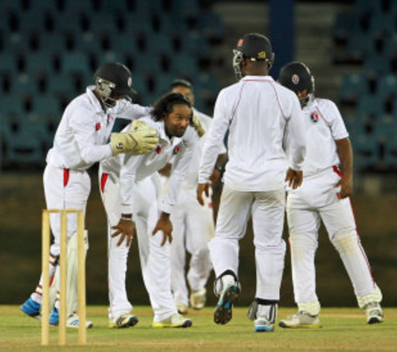 Team-mates congratulate Imran Khan after he took a wicket, Trinidad & Tobago v Combined Campuses and Colleges, Regional Four Day Competition, Port of Spain, March 30, 2014