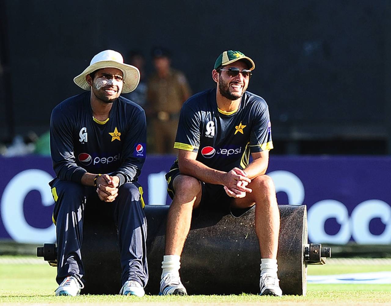 Umar Akmal and Shahid Afridi take a breather during Pakistan's practice session, Hambantota, August 25, 2014