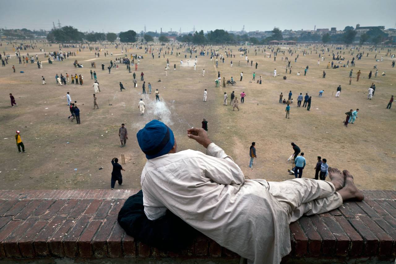 A man watches dozens of simultaneous games of cricket at Lahore's Iqbal Park, December 12, 2010