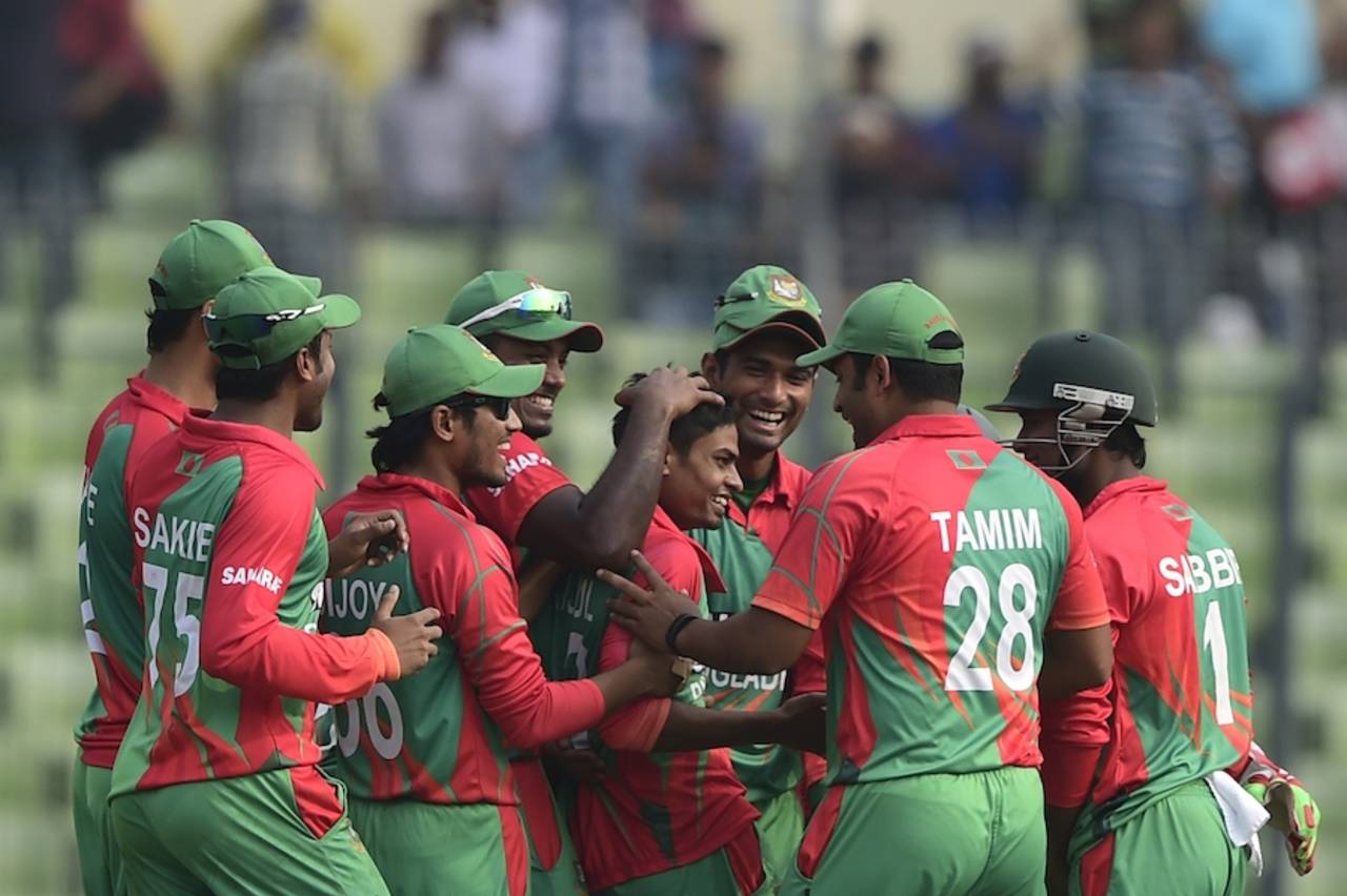 Taijul Islam is mobbed by team-mates after his hat-trick, Bangladesh v Zimbabwe, 5th ODI, Mirpur, December 1, 2014