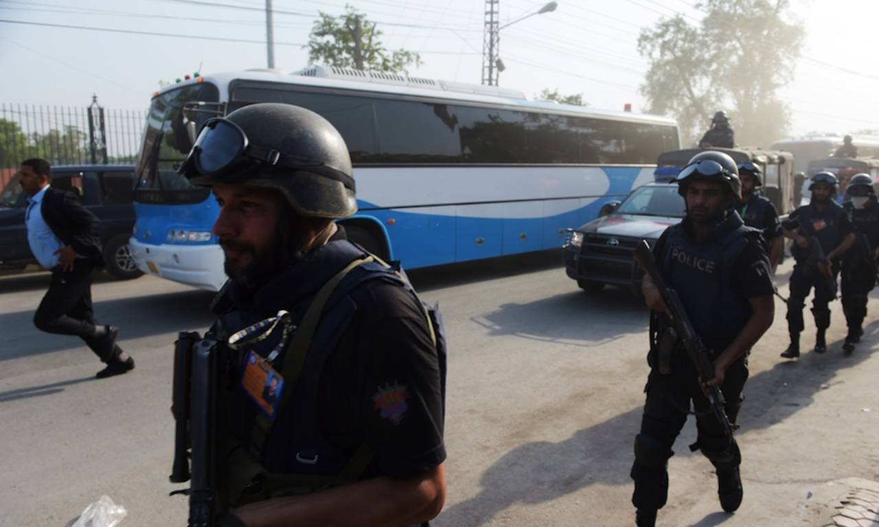 The team buses of the Pakistan and Zimbabwe teams flanked by policemen, Lahore, May 20, 2015